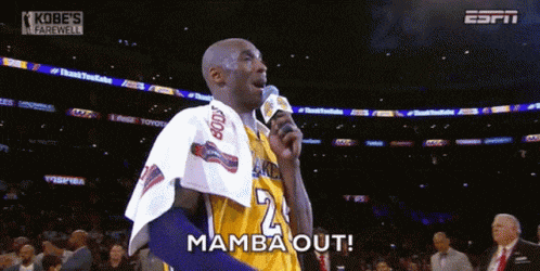 kobe bryant is speaking into a microphone while wearing a yellow jersey with the number 23 on it