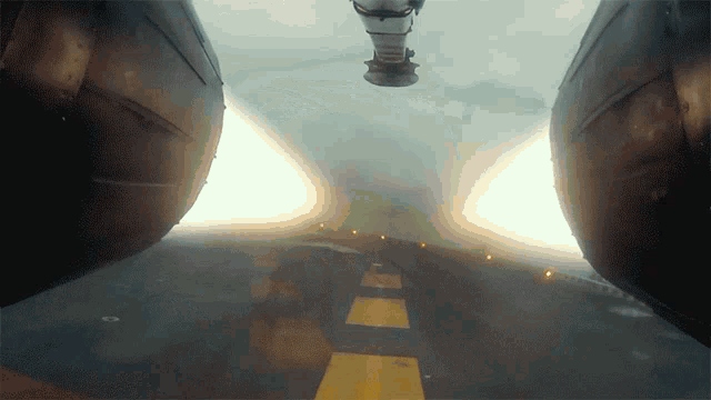 a plane is taking off from a runway with a yellow line on it