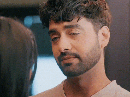 a man with a beard is looking at a woman with a sad look on his face .