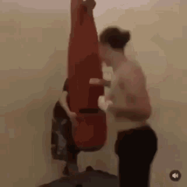 a man is standing next to a punching bag .