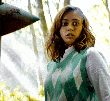 a woman wearing a green and white sweater vest
