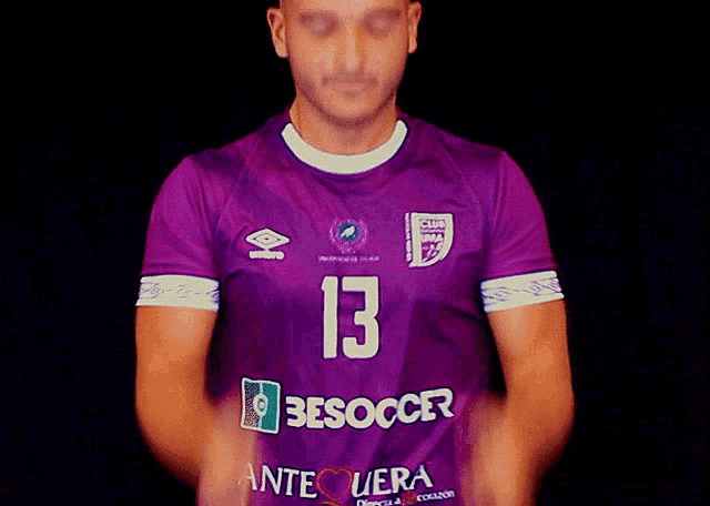 a man wearing a purple besoccer jersey with the number 13 on it
