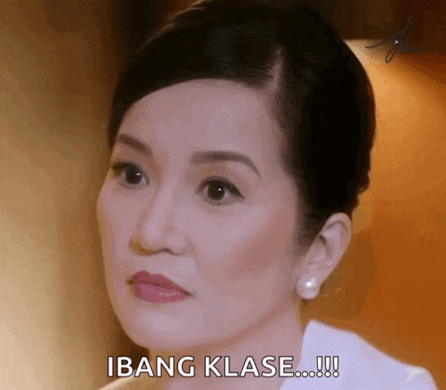 a woman in a white shirt is making a funny face and saying ibang klase !!!