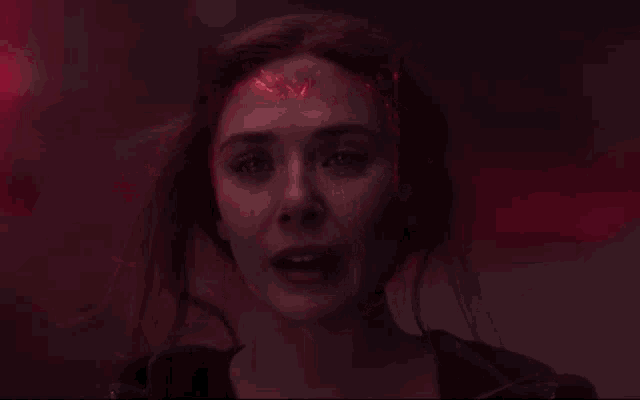 a close up of a woman 's face with a red background .