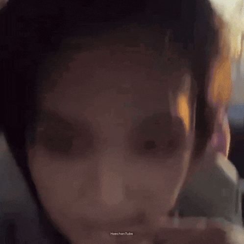 a close up of a person 's face in a car with a blurry background .