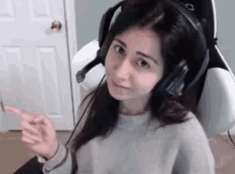 a girl wearing headphones and a microphone is pointing at something .