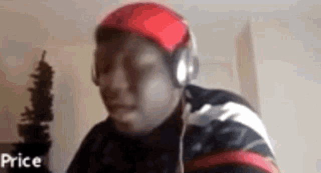 a man is wearing headphones and a red hat .