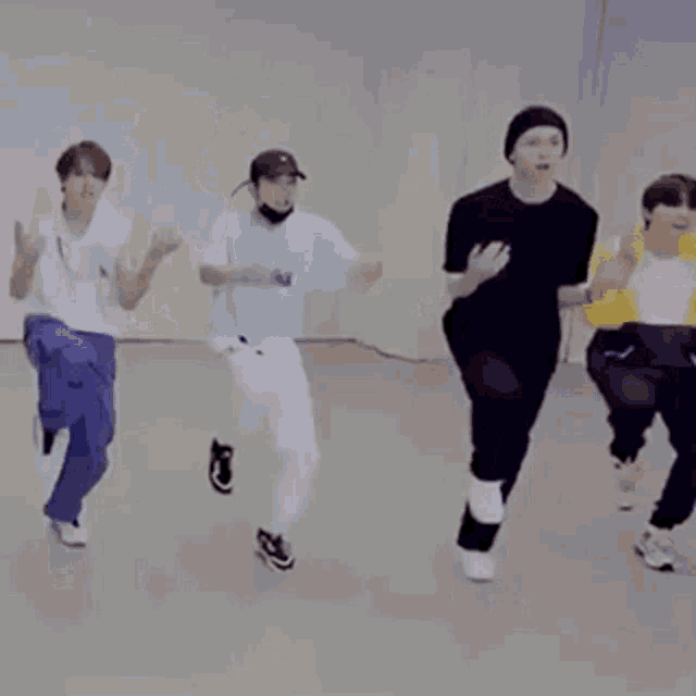 a group of young men are dancing together in a room .