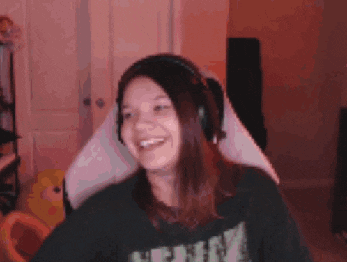 a woman wearing headphones and a black shirt that says ' skeleton ' on it