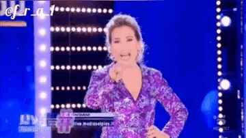 a woman in a purple dress stands in front of a blue background