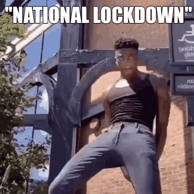 a man is dancing in front of a brick building with the words `` national lock down '' written above him .