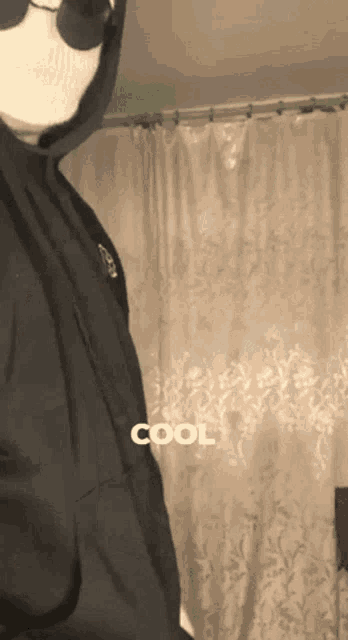 a person wearing a mask and a hoodie with the word cool on it