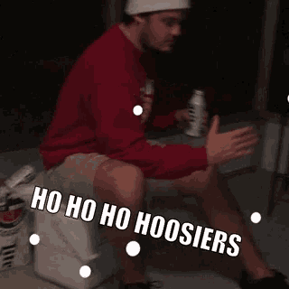 a man is sitting on a cooler with the words ho ho ho hoosier written on his leg