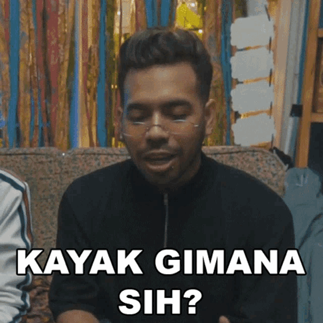 a man is sitting on a couch and says kayak gimana sih ?