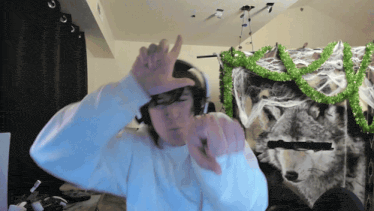 a man wearing headphones stands in front of a wall with a picture of a wolf and spider webs