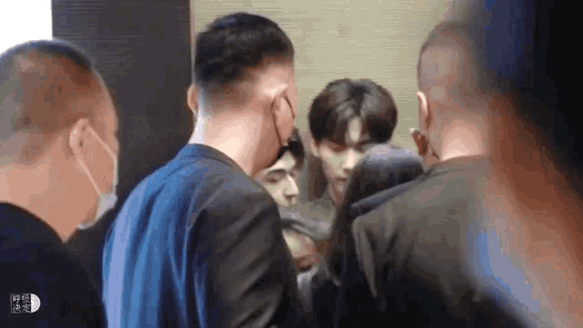 a group of men in suits and masks are standing around a man .
