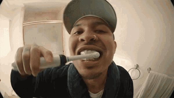 a man is brushing his teeth with an electric toothbrush