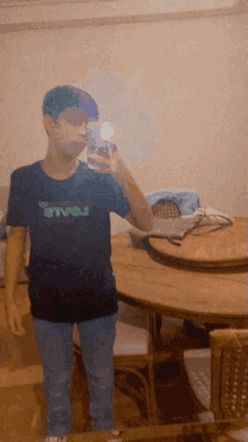 a boy taking a selfie in front of a mirror wearing a levi 's shirt