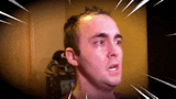 a close up of a man 's face with a surprised look on his face .