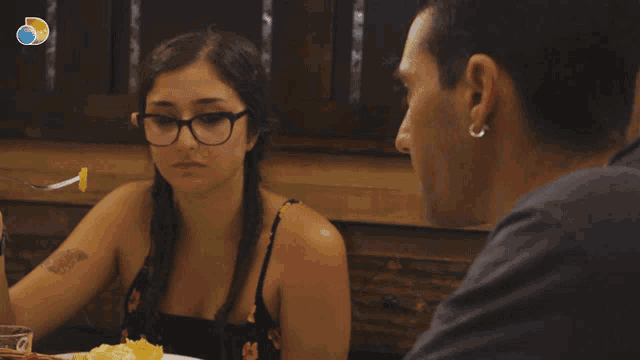 a man and a woman are sitting at a table with the words ci sto provando behind them