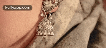 a close up of a woman wearing a pair of silver earrings