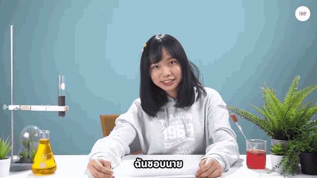 a girl wearing a hoodie that says 1969 sits at a desk