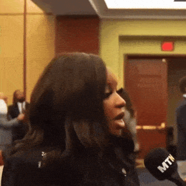 a woman speaking into a mtn microphone in a room