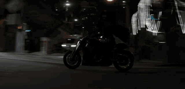 a woman is riding a motorcycle down a city street