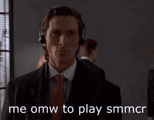 a man in a suit and tie is wearing headphones and says me omw to play smmcr