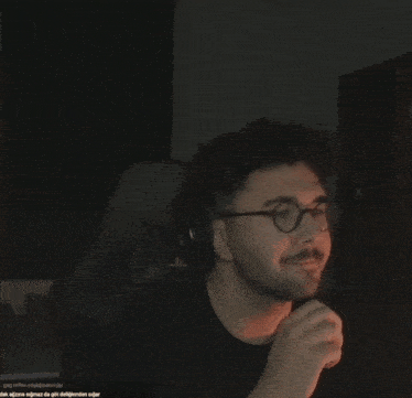 a man wearing glasses and headphones is giving the thumbs up