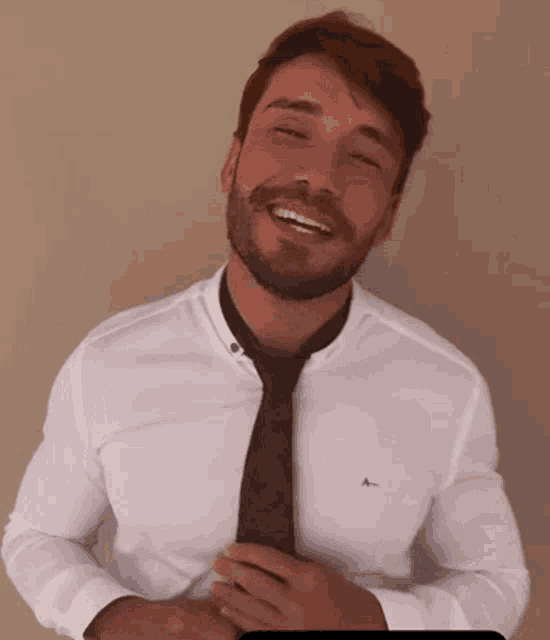 a man wearing a white shirt and a black tie is smiling