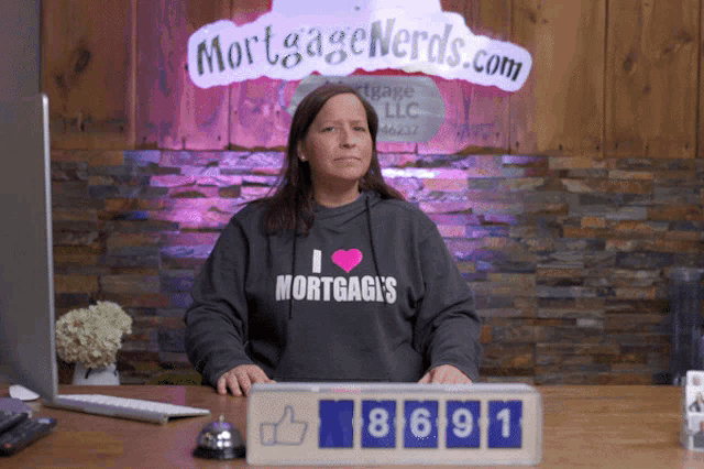a woman wearing a sweatshirt that says i love mortgage 's