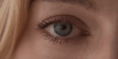 a close up of a woman 's blue eye with mascara on