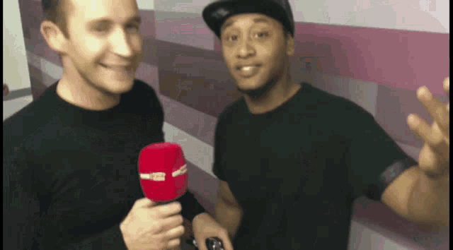 a man in a black shirt holds a red microphone that says radio