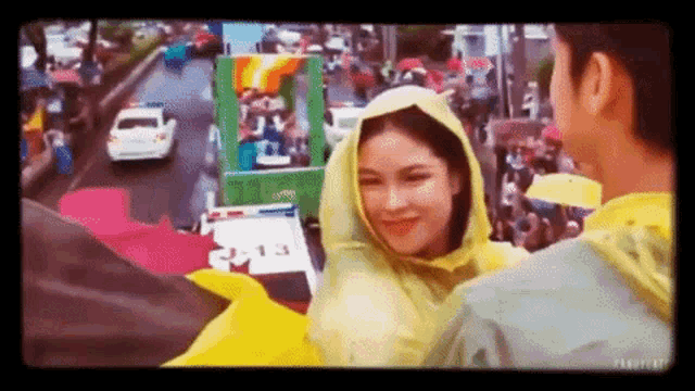 a man and a woman are standing next to each other in front of a crowd .