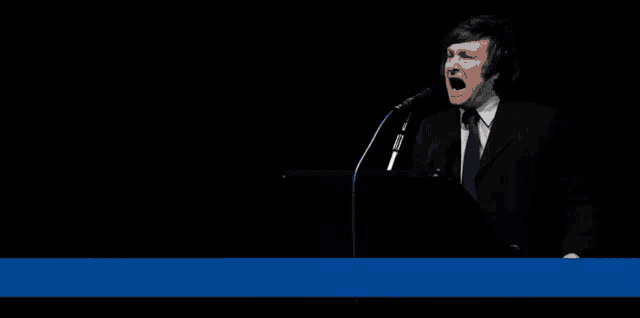 a man singing into a microphone with the words vota milei written above him