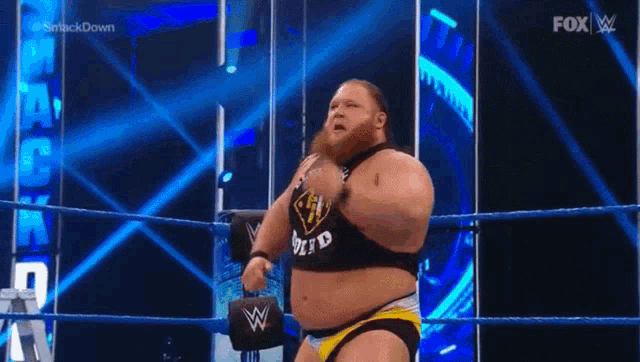 a fat man is standing in a wrestling ring .