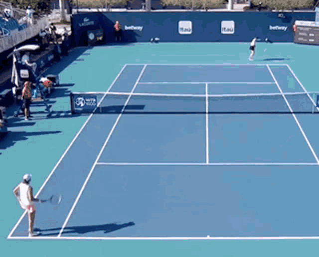 a woman is playing tennis in front of a cadillac ad