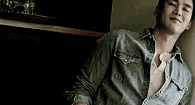 a man in a denim shirt is laying on the floor