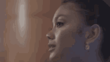 a close up of a woman 's face with earrings .