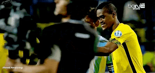 a soccer player in a yellow jersey is talking to another player in a black jersey