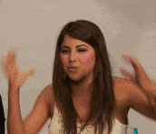 a woman in a white tank top is making a funny face