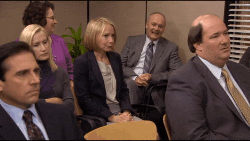 a group of people in suits and ties are sitting in a waiting room