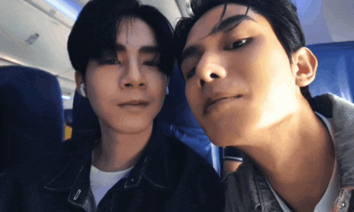 two men are sitting next to each other on a bus