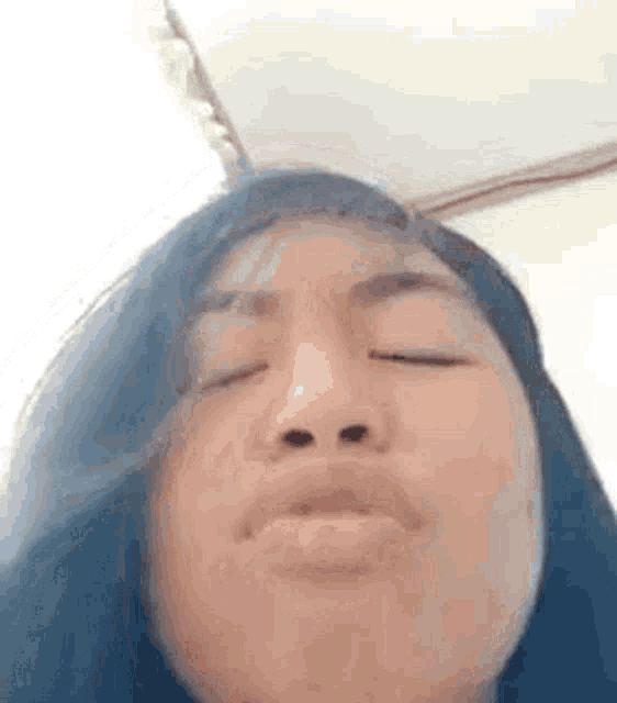 a close up of a woman 's face with her eyes closed and her mouth open .