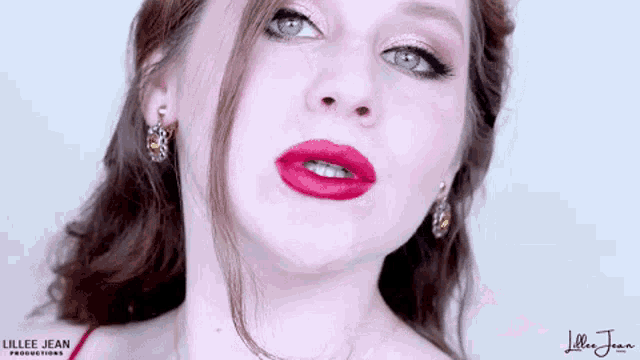 a close up of a woman 's face with red lips and earrings