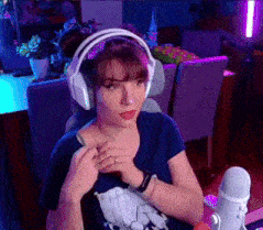 a woman wearing headphones is sitting in front of a microphone in a dark room .