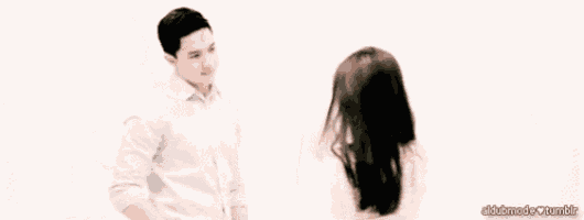 a man and a woman are standing next to each other in front of a white background .