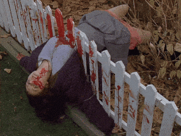 a woman is laying on the ground with blood on her face