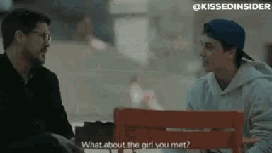 two men are sitting on a bench talking to each other and one of them is asking the other what about the girl you met .